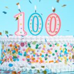 Birthday cake with candles (100) on a light blue background
