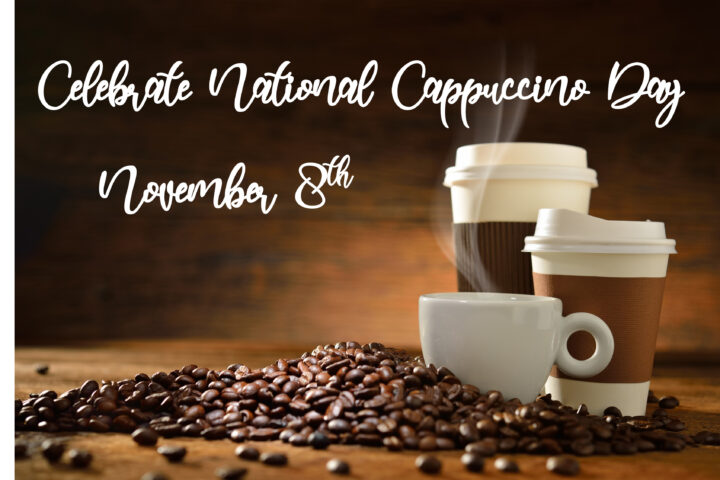 Celebrate National Cappuccino Day on November 8th. A cozy arrangement of a steaming white coffee cup and two to-go coffee cups surrounded by coffee beans, set against a warm, rustic wooden background.