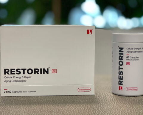 A promotional image showcasing the RESTORIN® product packaging and bottle. The white box with bold black text "RESTORIN SE" and the accompanying bottle labeled "Cellular Energy & Repair Aging Optimization" are placed on a neutral surface, with a blurred natural background that emphasizes innovation and health. The sleek, minimalist design of the packaging highlights RESTORIN®'s focus on advanced scientific research targeting the root causes of aging, including mTOR modulation, senolytics, and sirtuin activation.