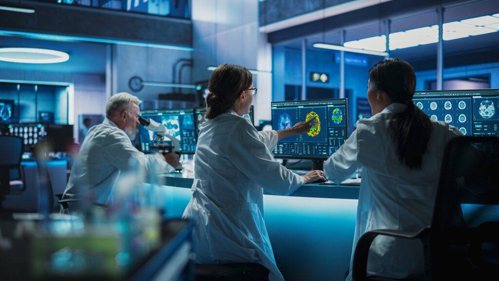 Scientists in a futuristic laboratory analyzing brain scans and cellular data on advanced monitors, with a focus on cutting-edge research and biomedical innovation. The scene emphasizes teamwork, advanced technology, and longevity science.