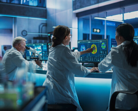 Scientists in a futuristic laboratory analyzing brain scans and cellular data on advanced monitors, with a focus on cutting-edge research and biomedical innovation. The scene emphasizes teamwork, advanced technology, and longevity science.