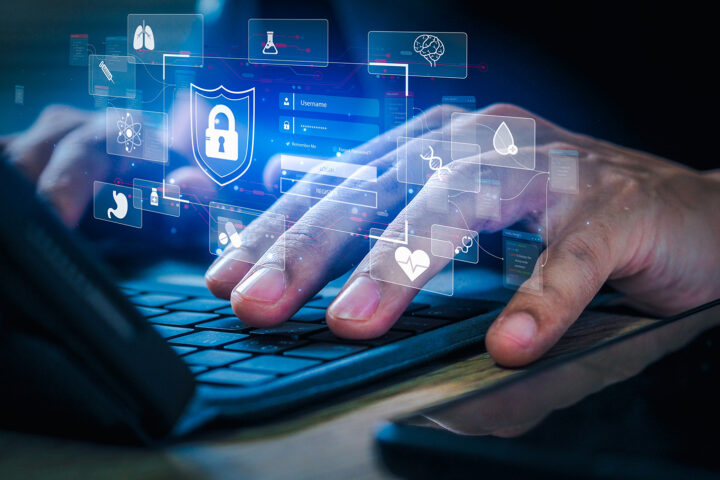 Close-up of hands typing on a keyboard with a digital overlay of health-related icons like DNA, a heart, and a brain, representing the role of DNA methylation research in decoding and potentially reversing the aging process.