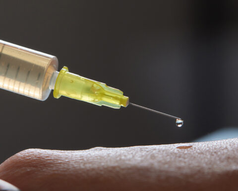 Close-up of a syringe releasing a droplet of fluid onto human skin, symbolizing regenerative medicine and stem cell therapy. The image represents emerging biomedical interventions aiming to restore stem cell function and reverse signs of aging. Would you like a version with more emphasis on specific concepts like epigenetic reprogramming, extracellular vesicles, or clinical translation?